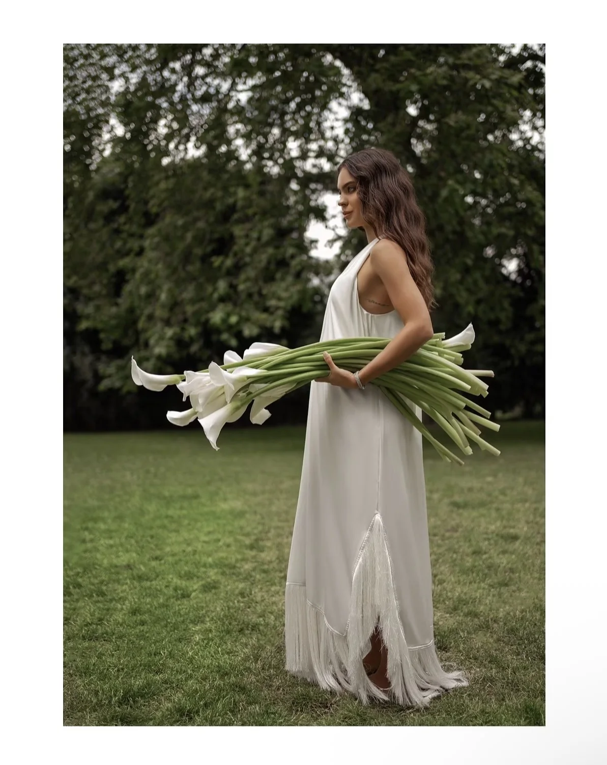 White dress beauty editorial with calla lilies in a garden